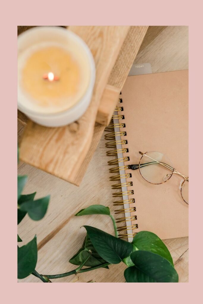 calming candle on book with glasses